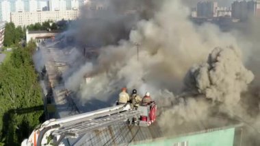 Nizhnevartovsk, Rusya - 1 Temmuz 2019: İtfaiyeciler yüksek katlı bir binanın çatısında çıkan yangını söndürdü
