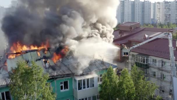 Nizhnevartovsk, Ryssland-1 juli 2019: brandmän släcka en brand på taket av ett bostadshus höghus — Stockvideo