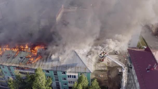 Nizhnevartovsk, Oroszország-július 1, 2019: tűzoltó eloltani a tetőn egy lakossági sokemeletes épület — Stock videók