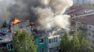 Nizhnevartovsk, Rusya - 1 Temmuz 2019: İtfaiyeciler yüksek katlı bir binanın çatısında çıkan yangını söndürdü