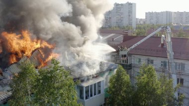 Nizhnevartovsk, Rusya - 1 Temmuz 2019: İtfaiyeciler yüksek katlı bir binanın çatısında çıkan yangını söndürdü