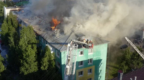 Nizhnevartovsk, Rusya - 1 Temmuz 2019: İtfaiyeciler yüksek katlı bir binanın çatısında çıkan yangını söndürdü