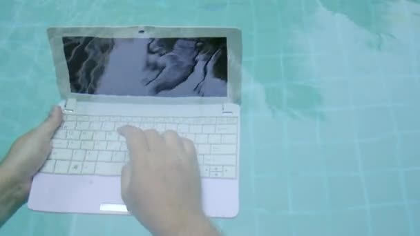Man arbetar på minidator under vatten. Minidator längst ner i poolen. Konceptet med mycket arbete på jobbet. Oskärpa abstrakt bakgrund. — Stockvideo