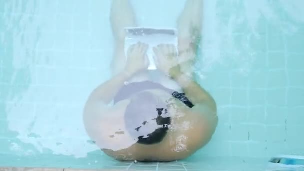 Männchen arbeitet am Computer unter Wasser im Pool. — Stockvideo