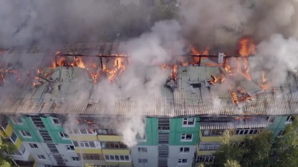 O telhado de uma casa residencial está a arder. bombeiros extinguir um incêndio no telhado de um edifício residencial de arranha-céus . — Vídeo de Stock