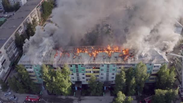 Das Dach eines Wohnhauses brennt. Feuerwehrleute löschen Brand auf Dach eines Wohnhochhauses. — Stockvideo