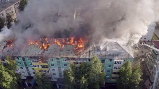 Dach domu mieszkalnych jest palenie. Strażacy gaszenia pożaru na dachu budynku mieszkalnym wieżowcu. — Wideo stockowe