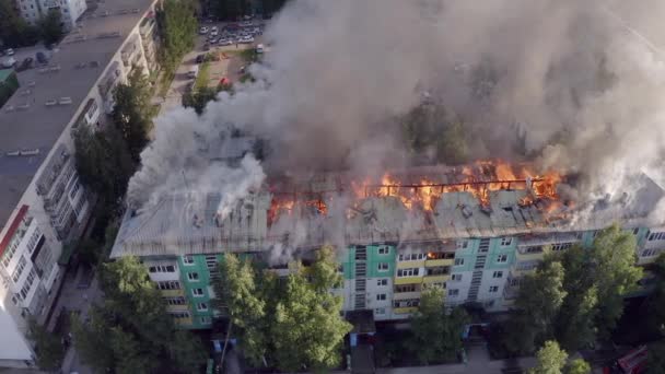 A tető egy lakóház ég. tűzoltók kioltják a tüzet a tetőn egy lakossági sokemeletes épület. — Stock videók