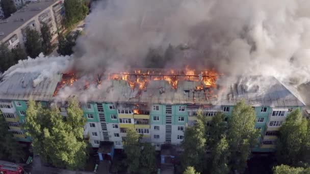 Het dak van een woonhuis brandt. Brandweerlieden blussen een brand op het dak van een residentiële hoogbouw. — Stockvideo