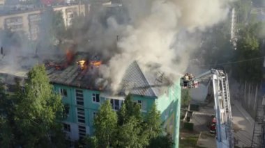 Bir konutun çatısı yanıyor. İtfaiyeciler bir konut yüksek katlı binanın çatısında bir yangın söndürmek.