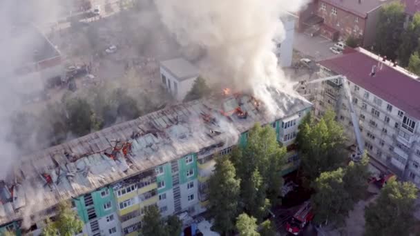 A tető egy lakóház ég. tűzoltók kioltják a tüzet a tetőn egy lakossági sokemeletes épület. — Stock videók