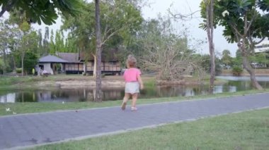 kızı deniz kenarında parkta yeşil çayır çalıştırmak