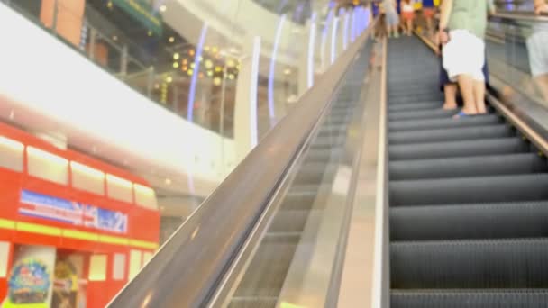 Rolltreppe im Einkaufszentrum in Großaufnahme. Im Hintergrund sind die Menschen beim Einkaufen aus dem Fokus. — Stockvideo