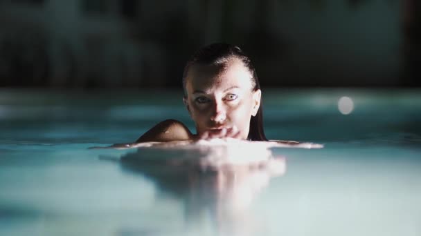 La ragazza con begli occhi la sera in piscina Guardando la macchina fotografica . — Video Stock