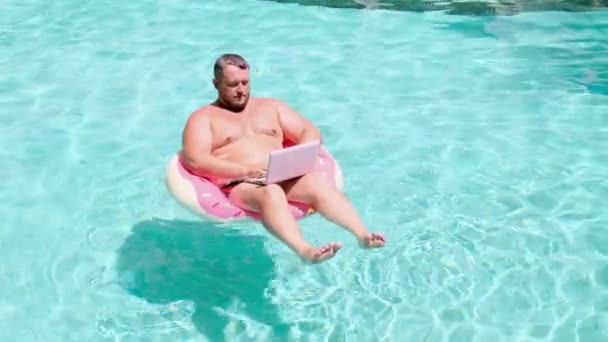 水の中のゴムリングにラップトップを持つ男性ビジネスマン — ストック動画