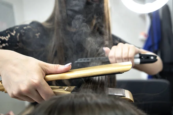 Peluquería hace laminación de cabello en un salón de belleza para una chica con pelo morena —  Fotos de Stock