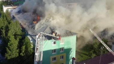 Nizhnevartovsk, Rusya - 1 Temmuz 2019: İtfaiyeciler yüksek katlı bir binanın çatısında çıkan yangını söndürdü
