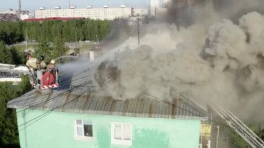 Nizhnevartovsk, Rusya - 1 Temmuz 2019: İtfaiyeciler yüksek katlı bir binanın çatısında çıkan yangını söndürdü