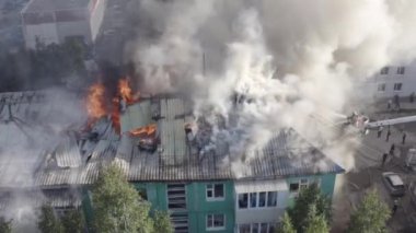 Bir konutun çatısı yanıyor. İtfaiyeciler bir konut yüksek katlı binanın çatısında bir yangın söndürmek.