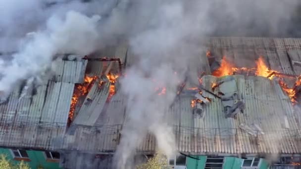 Taket på ett bostadshus brinner. brandmän släcka en brand på taket av ett bostadshus höghus. — Stockvideo