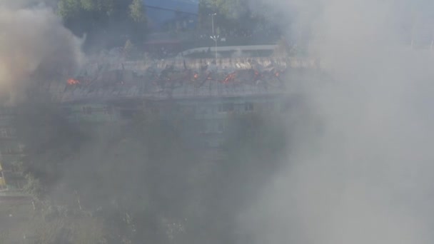 Taket på ett bostadshus brinner. brandmän släcka en brand på taket av ett bostadshus höghus. — Stockvideo