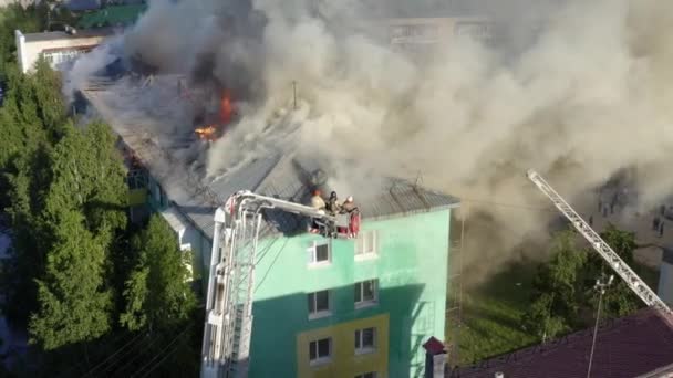 Nizhnevartovsk, Oroszország-július 1, 2019: tűzoltó eloltani a tetőn egy lakossági sokemeletes épület — Stock videók