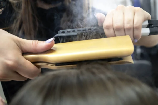 Peluquería hace laminación de cabello en un salón de belleza para una chica con pelo morena — Foto de Stock