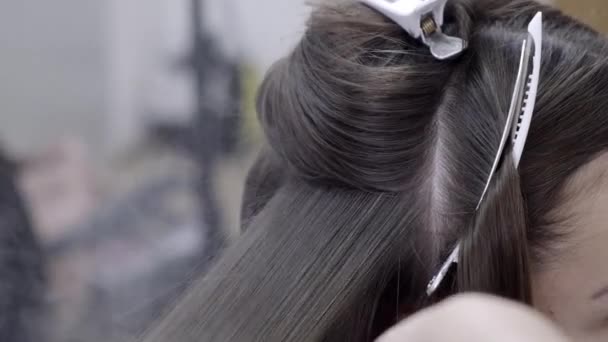 Peluquería hace laminación de cabello en un salón de belleza para una chica con pelo morena — Vídeos de Stock