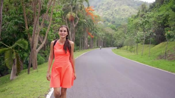 Hermosa selva tropical con una joven viajera en el camino hacia el bosque Tailandia. Caminatas femeninas en un camino de selva tropical y disfruta de las vistas de la naturaleza — Vídeos de Stock