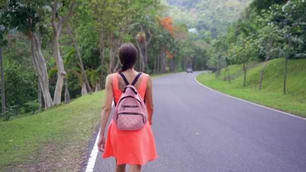 Hermosa selva tropical con una joven viajera en el camino hacia el bosque Tailandia. Caminatas femeninas en un camino de selva tropical y disfruta de las vistas de la naturaleza — Vídeos de Stock