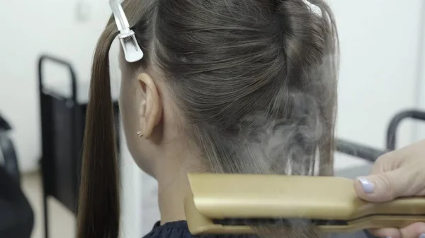 Coiffeur fait stratification des cheveux dans un salon de beauté pour une fille aux cheveux bruns — Photo