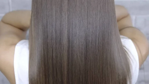 Risultato dopo la laminazione e raddrizzamento dei capelli in un salone di bellezza per una ragazza con i capelli castani. concetto di cura dei capelli — Foto Stock