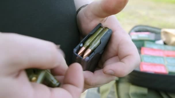 Male fingers load the cartridge rifle one by one — Stock Video