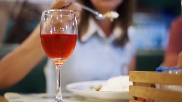 Pár vacsorázni egy pohár bort hűvös este ül egy étteremben bokeh fény homályos háttér. Pár vacsora egy pohár borral — Stock videók
