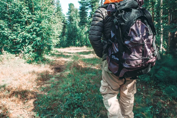 A man with a large tourist backpack traveling through the woods, ecotourism concept. — Stock Photo, Image