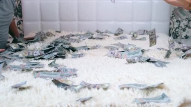 Bir adam ve kadın beyaz bir yatakta oturan para paylaşmak, denbgs acele eğlenmek ve onları düşünün. Yukarıdan görüntüleyin. Çok para. Hızlı para kavramı