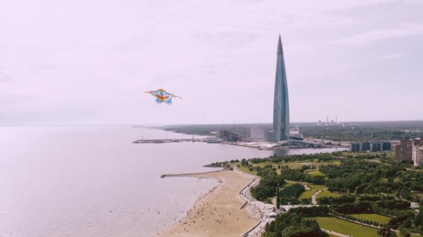 Un aquilone che vola vicino alla riva del fiume, vicino a un bellissimo edificio alto. Concetto di libertà e successo — Video Stock