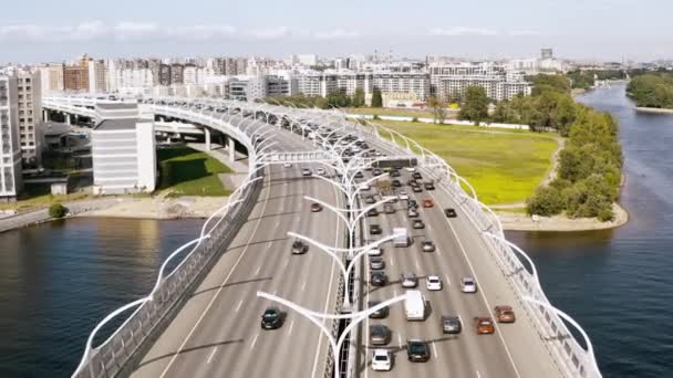 Een soepele lucht vlucht, een vlucht over een brug staande over een rivier waarop auto's rijden. 4k. — Stockvideo