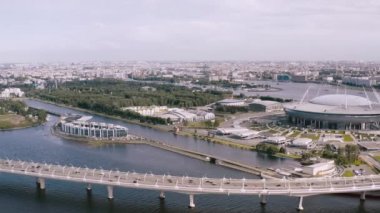 Pürüzsüz bir hava uçuşu, arabaların bindiği bir nehrin üzerinde duran bir köprüüzerinde bir uçuş. 4k.