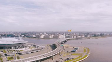 Pürüzsüz bir hava uçuşu, arabaların bindiği bir nehrin üzerinde duran bir köprüüzerinde bir uçuş. 4k.