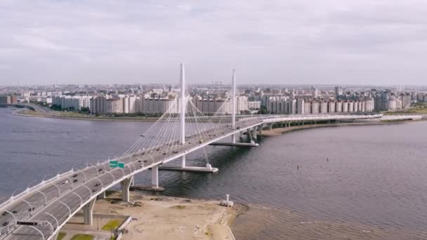 Гладкий воздушный полет, полет над мостом, стоящим над рекой, на которой ездят машины. 4k . — стоковое видео