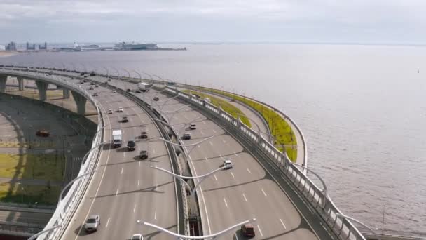 Een soepele lucht vlucht, een vlucht over een brug staande over een rivier waarop auto's rijden. 4k. — Stockvideo