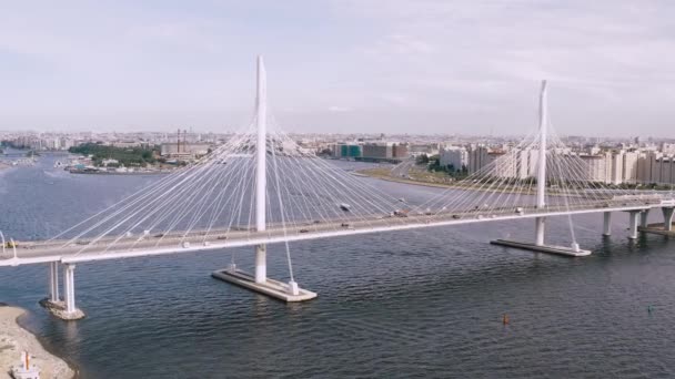 Μια ομαλή εναέρια πτήση, μια πτήση πάνω από μια γέφυρα που στέκεται πάνω από ένα ποτάμι στο οποίο ιππεύεις αυτοκίνητα. 4K. — Αρχείο Βίντεο
