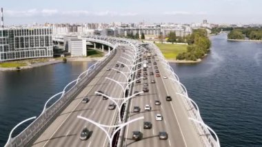 Pürüzsüz bir hava uçuşu, arabaların bindiği bir nehrin üzerinde duran bir köprüüzerinde bir uçuş. 4k.