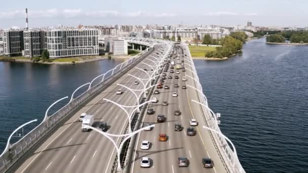 Ein sanfter Luftflug, ein Flug über eine Brücke, die über einem Fluss steht, auf dem Autos fahren. 4k. — Stockvideo