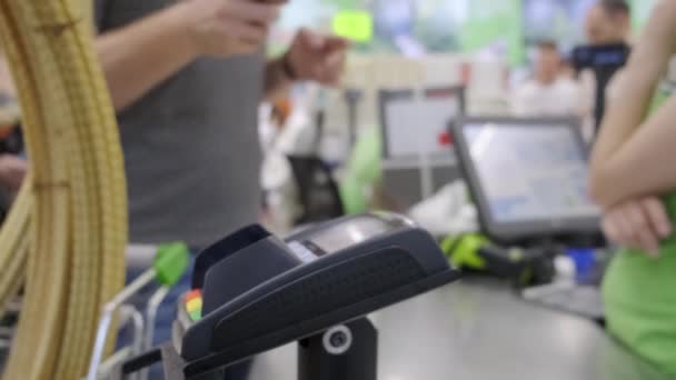Kupujący w sklepie płaci za towar telefonicznie, płatność zbliżona. — Wideo stockowe