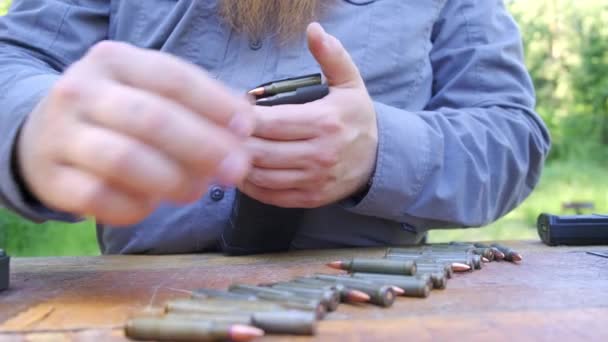 Mannelijke vingers het cartridge geweer één voor één laden — Stockvideo