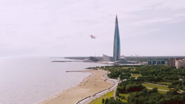 Un aquilone che vola vicino alla riva del fiume, vicino a un bellissimo edificio alto. Concetto di libertà e successo — Video Stock