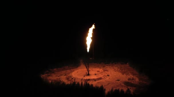 Огромный факел огня горит посреди леса ночью. газопереработка, концепция загрязнения окружающей среды, глобальное потепление — стоковое видео