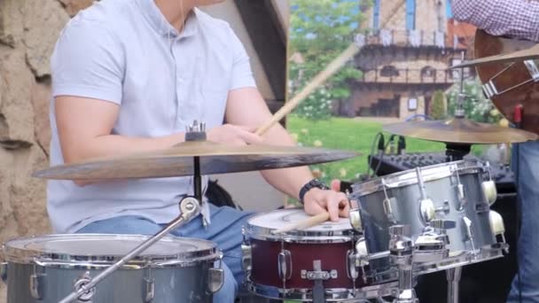 Un batterista musicista con una camicia blu suona la batteria per strada. Da vicino. — Video Stock